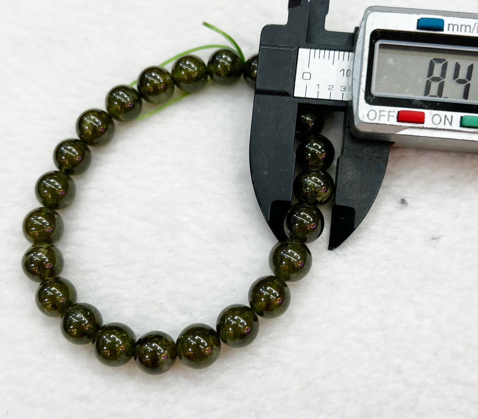 Armband aus Natursteinperlen aus grünem Hessonit, das Steine ​​anzieht